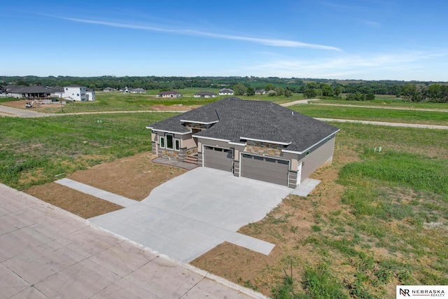 view of front of house featuring a garage, stone siding, concrete driveway, and roof with shingles