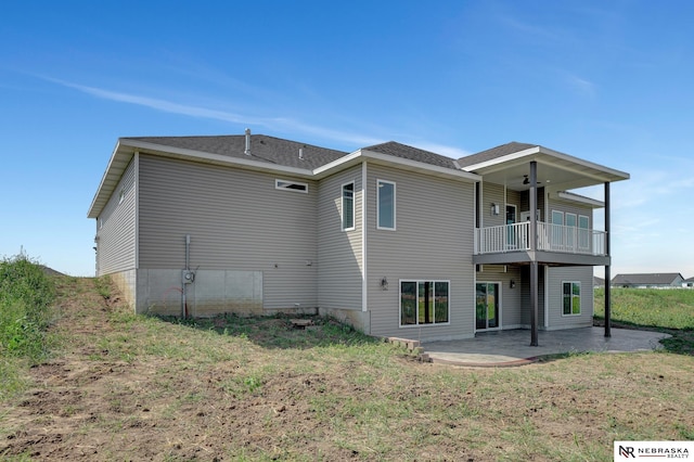 rear view of property with ceiling fan, a lawn, a patio area, and a balcony