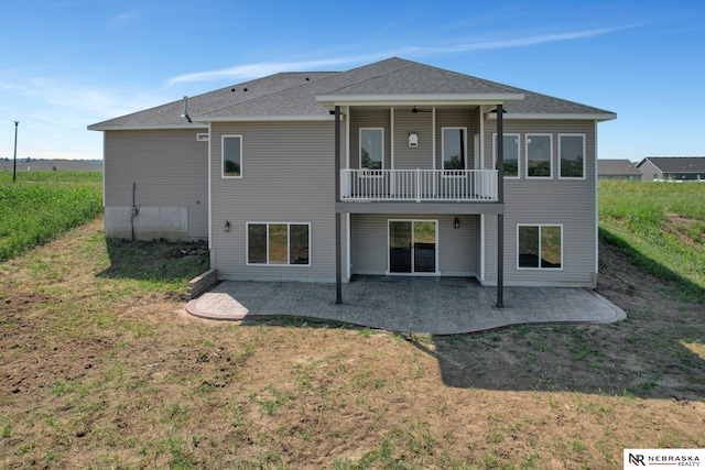 back of property featuring a yard, roof with shingles, and a patio