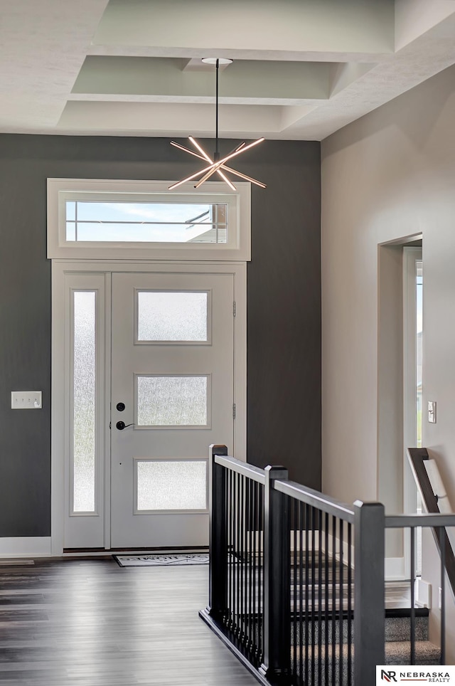 foyer with a chandelier, wood finished floors, and beamed ceiling