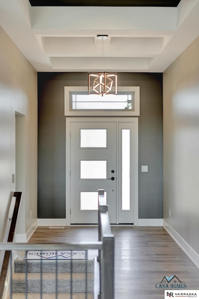 entrance foyer with plenty of natural light, beamed ceiling, baseboards, and wood finished floors