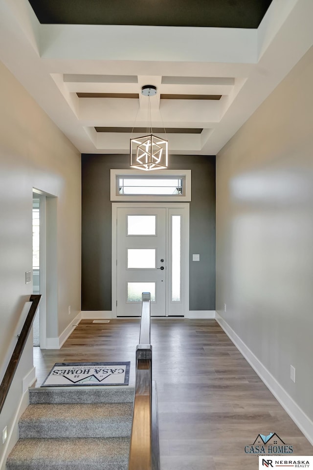 foyer entrance with a chandelier, coffered ceiling, wood finished floors, baseboards, and beam ceiling