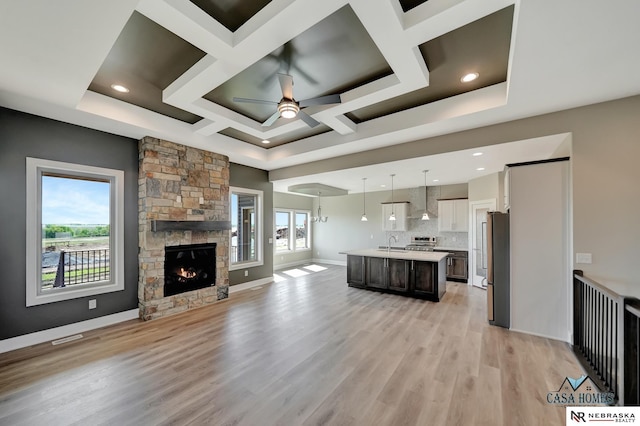 kitchen featuring a kitchen island with sink, pendant lighting, open floor plan, and light countertops