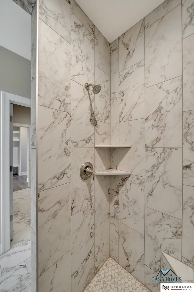 bathroom featuring marble finish floor and tiled shower