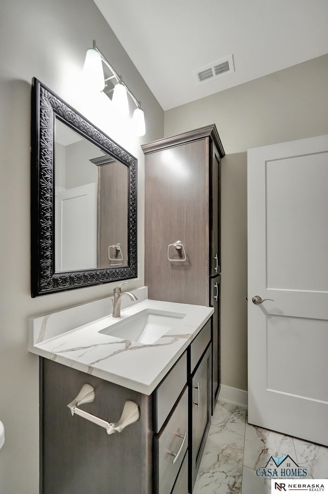 bathroom featuring marble finish floor, vanity, visible vents, and baseboards