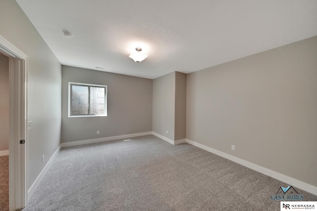 empty room with baseboards and light colored carpet