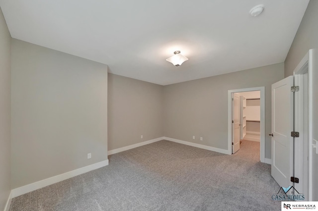 unfurnished room featuring baseboards and light colored carpet