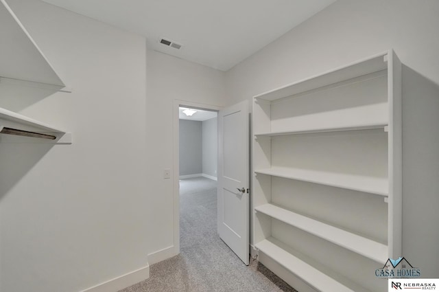 spacious closet featuring light colored carpet and visible vents