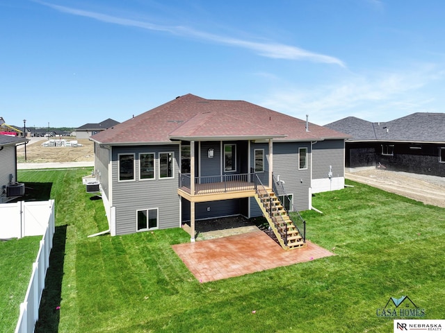 rear view of house with a shingled roof, stairs, fence, a yard, and a patio area