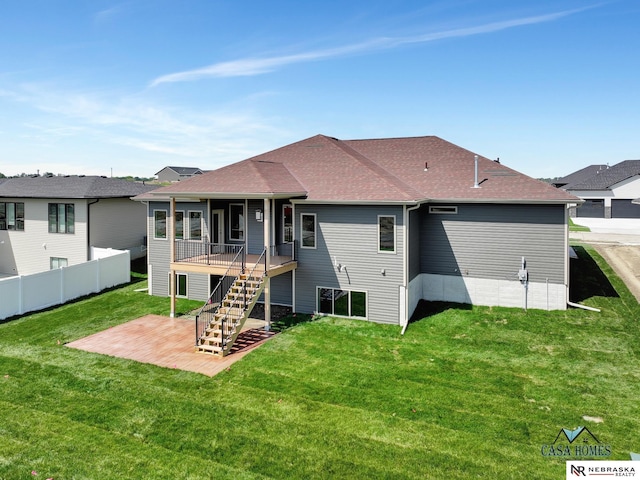 rear view of property featuring a patio, fence, stairway, and a lawn