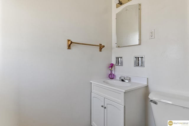 half bathroom featuring vanity and toilet