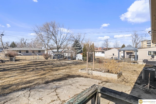 view of yard featuring a residential view, a vegetable garden, fence, and a gazebo