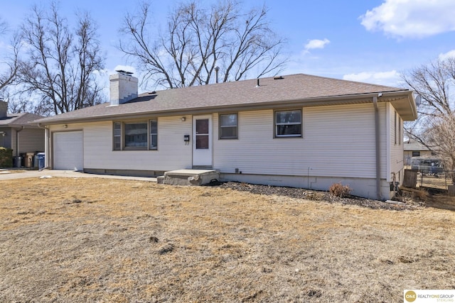 ranch-style house featuring a garage, a shingled roof, and a chimney