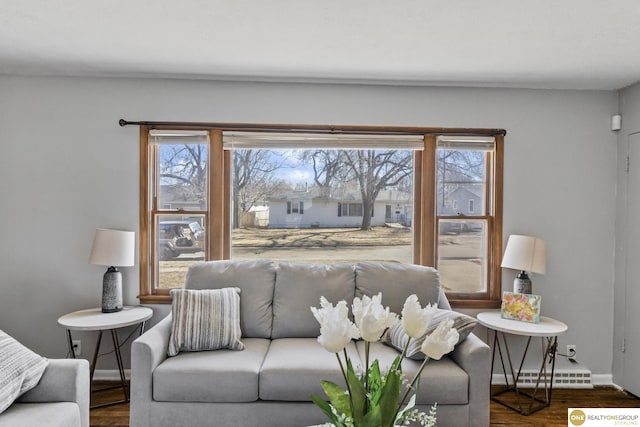 living room with dark wood finished floors, plenty of natural light, baseboards, and a baseboard radiator