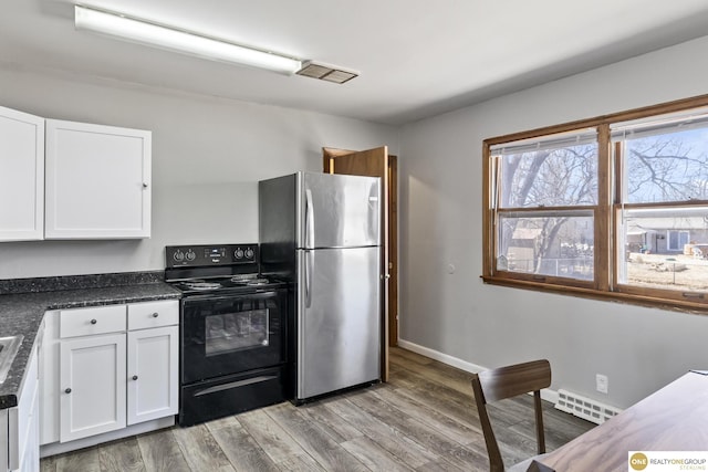 kitchen with visible vents, white cabinetry, black electric range, freestanding refrigerator, and dark countertops