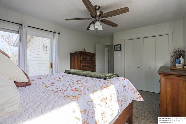 carpeted bedroom with a textured ceiling, a ceiling fan, and a closet