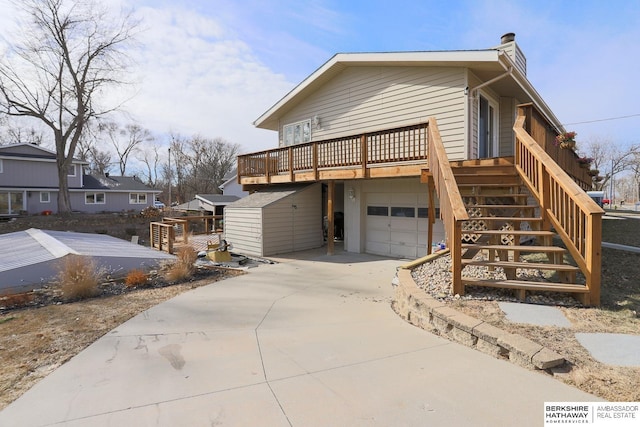 view of front of home with a deck, concrete driveway, stairway, and an attached garage