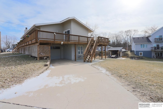 view of front of house featuring driveway, an attached garage, stairs, and a wooden deck