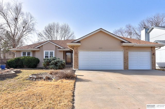 ranch-style home with a garage, driveway, and roof with shingles