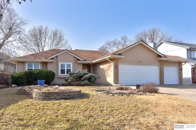 ranch-style home with driveway, a front lawn, roof with shingles, and an attached garage