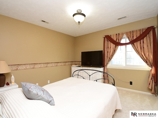 carpeted bedroom with visible vents and baseboards