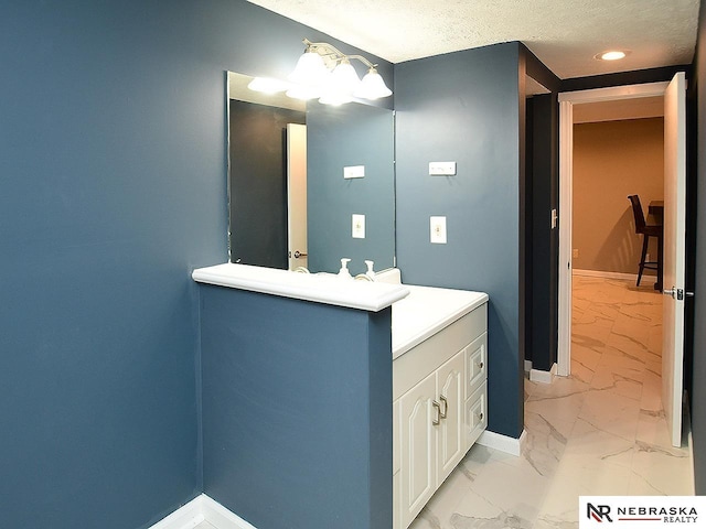 bathroom featuring baseboards, marble finish floor, a textured ceiling, vanity, and recessed lighting