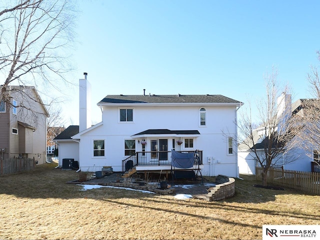 back of house with a deck, fence, a chimney, and stucco siding