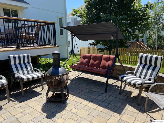 view of patio / terrace with an outdoor living space with a fire pit and fence