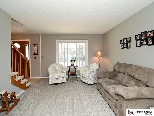 living room with stairs, baseboards, and a textured ceiling