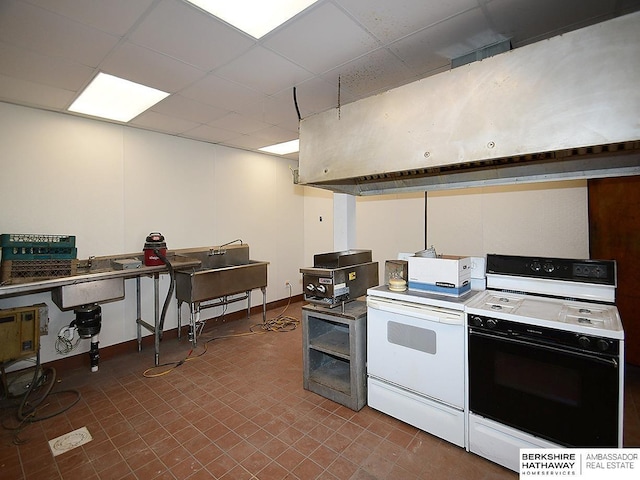 kitchen featuring electric stove, a drop ceiling, and baseboards