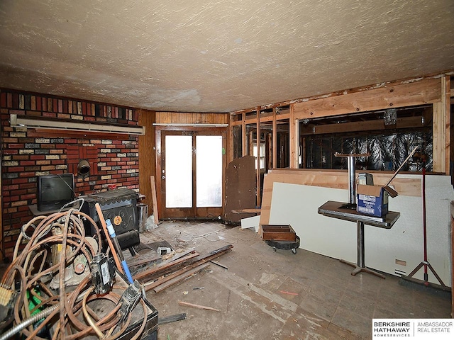 unfurnished living room with a textured ceiling and a wood stove