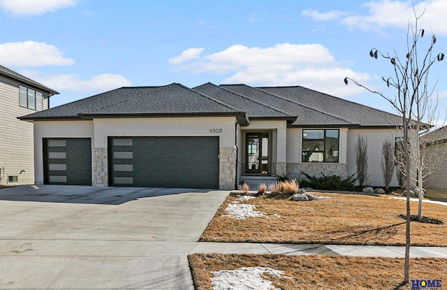 prairie-style house with concrete driveway, stone siding, an attached garage, and stucco siding