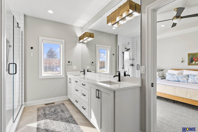 ensuite bathroom featuring a healthy amount of sunlight, a stall shower, a sink, and connected bathroom