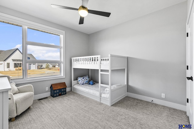 bedroom with light carpet, ceiling fan, visible vents, and baseboards