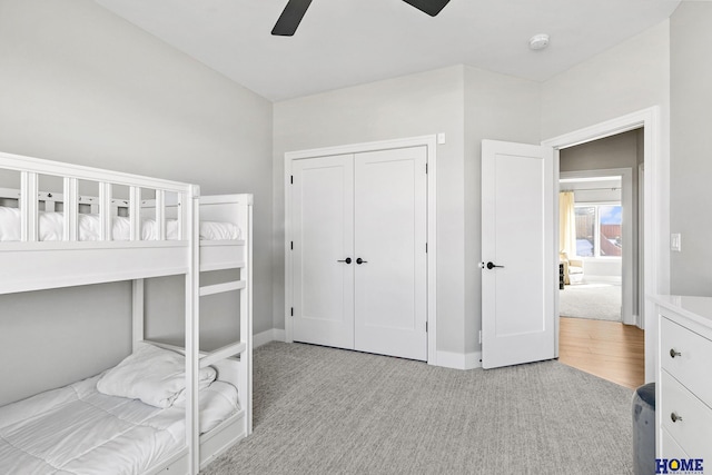 bedroom with a closet, light carpet, and baseboards