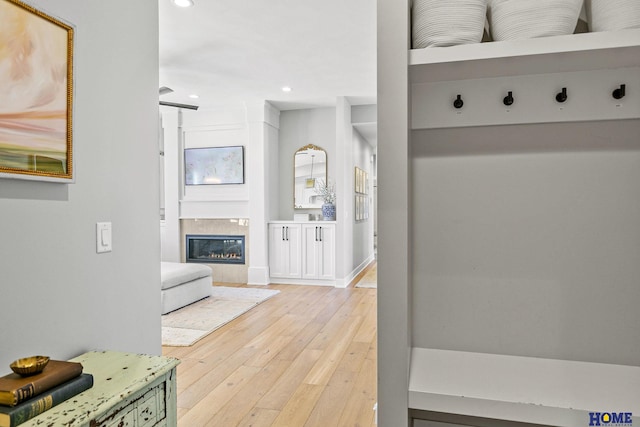 mudroom with hardwood / wood-style flooring, recessed lighting, and a glass covered fireplace