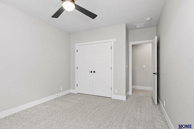 unfurnished bedroom featuring light colored carpet, a ceiling fan, baseboards, visible vents, and a closet