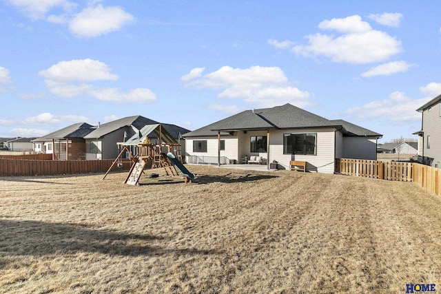 exterior space featuring a residential view, a playground, fence, and a patio