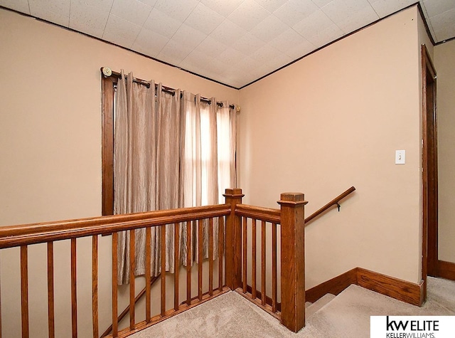 stairway featuring carpet floors and baseboards