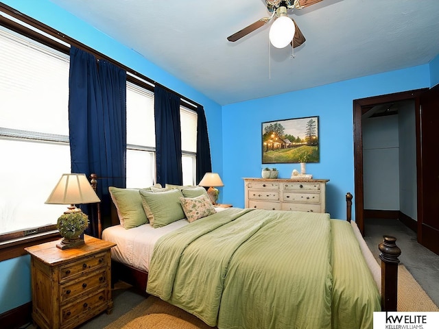 carpeted bedroom with ceiling fan and baseboards