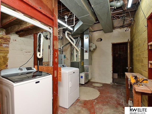 clothes washing area featuring laundry area, washer and clothes dryer, and heating unit