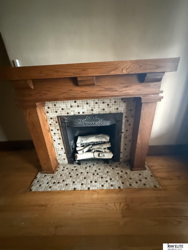 details featuring a fireplace and wood finished floors