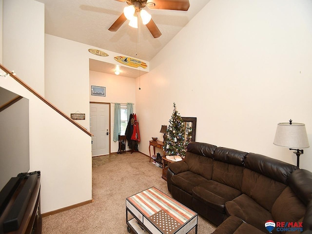 living room featuring light colored carpet, stairway, a ceiling fan, high vaulted ceiling, and baseboards