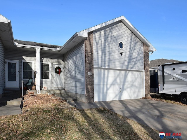 view of front of property featuring entry steps, a garage, and concrete driveway