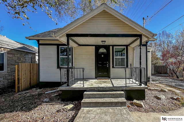 bungalow-style house with a porch and fence