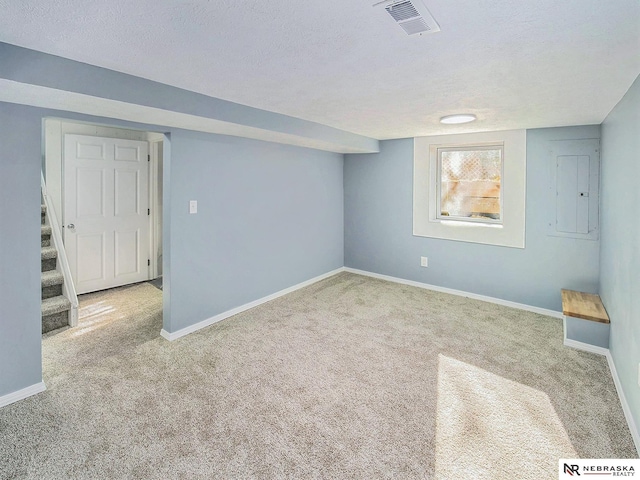 below grade area featuring carpet floors, visible vents, baseboards, and stairs