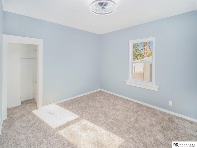 empty room with carpet and baseboards