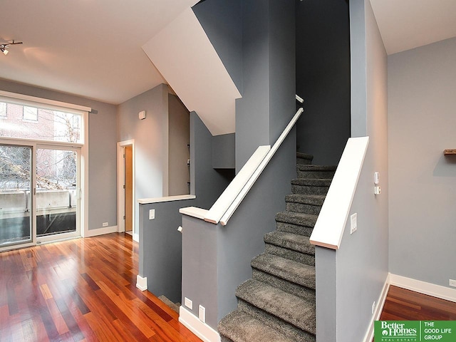 staircase with baseboards and wood finished floors