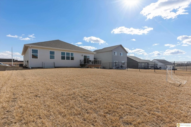 rear view of property with a yard and fence