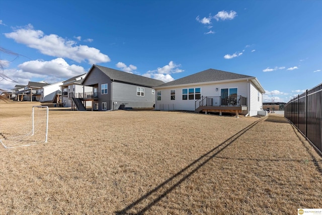 rear view of house with fence and a wooden deck